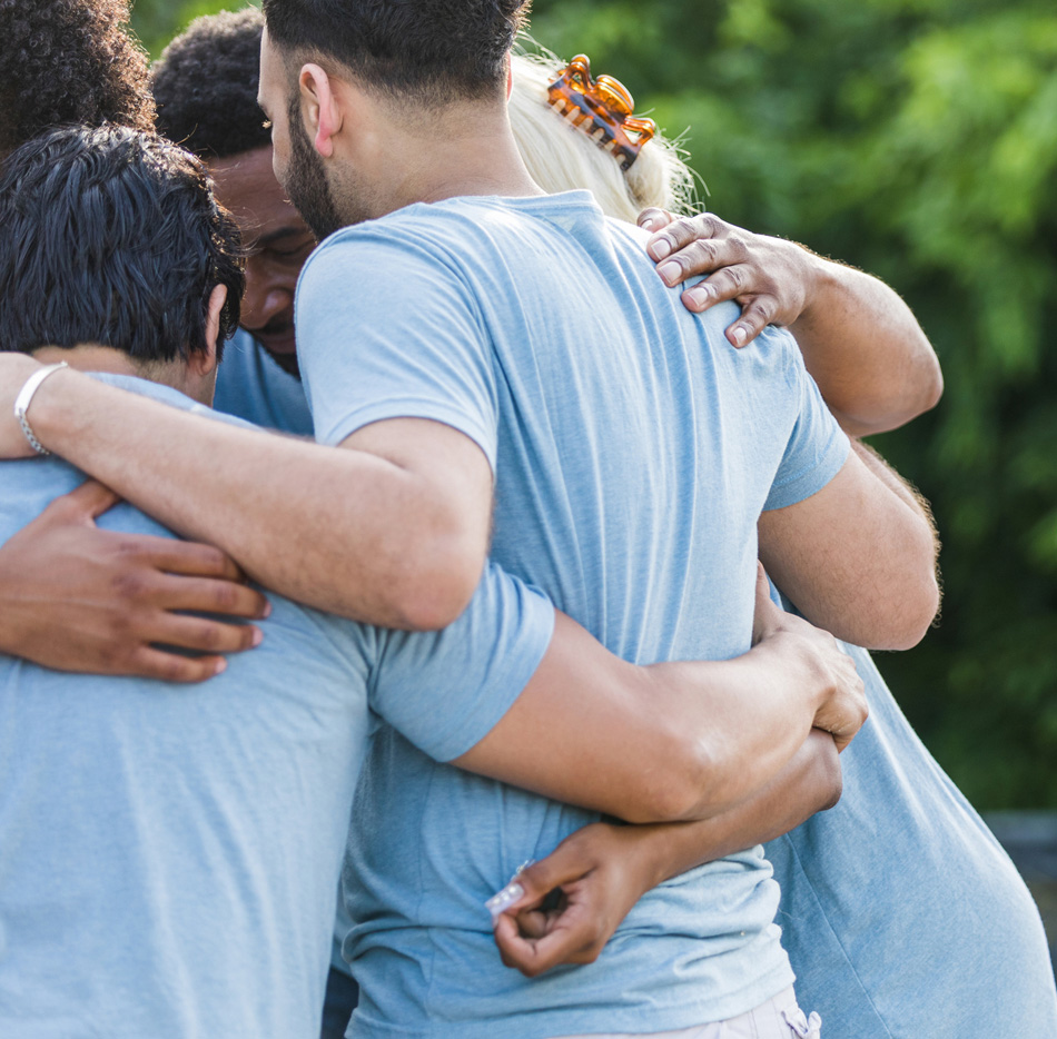 Team with arms around each other in group huddle