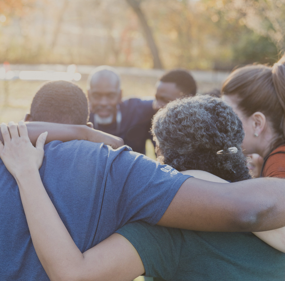 Team of volunteers embraced in huddle