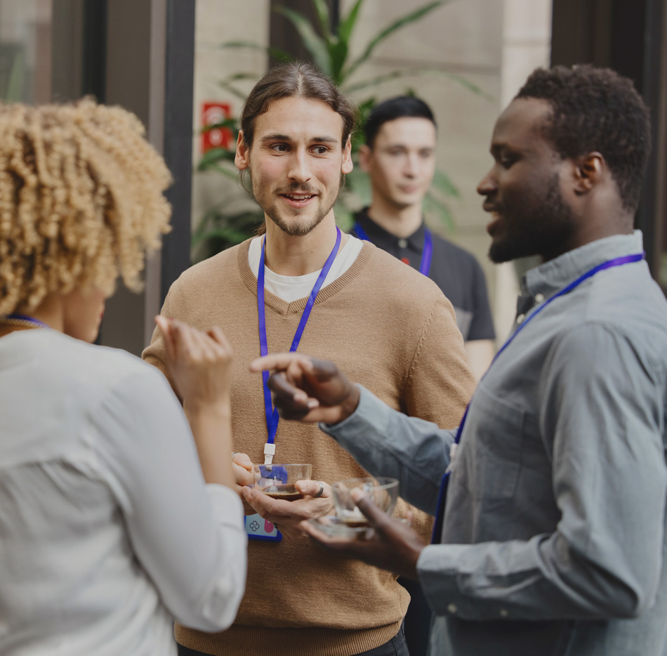 Group of three people conversing at a conference